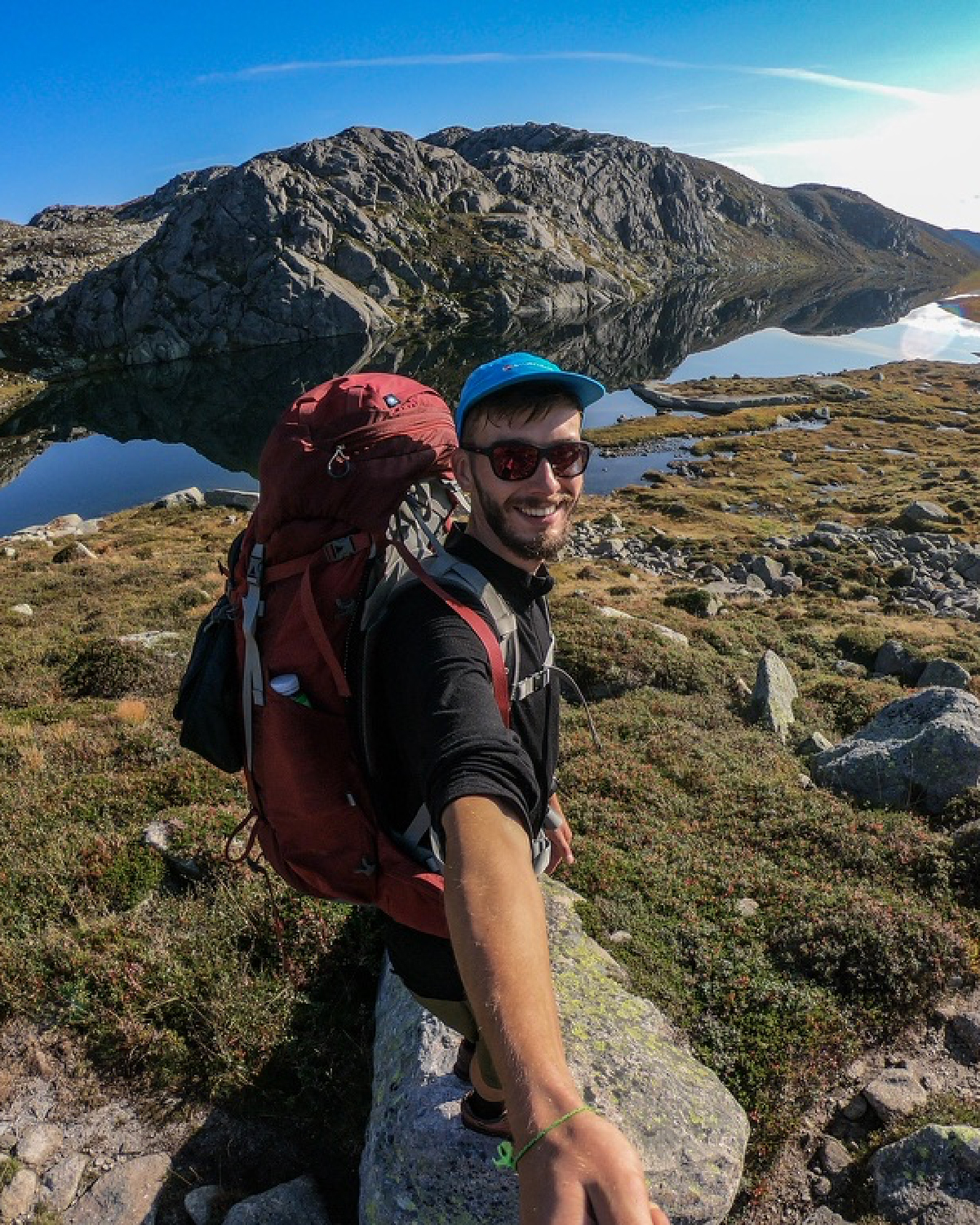 A solo hiker seen from behind on a mountain ridge
